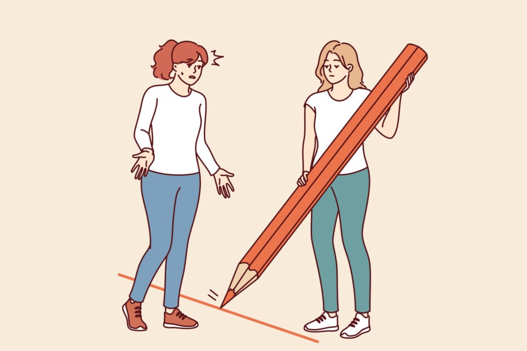 A woman uses a large red pencil to draw a line between her and someone else - setting a boundary.