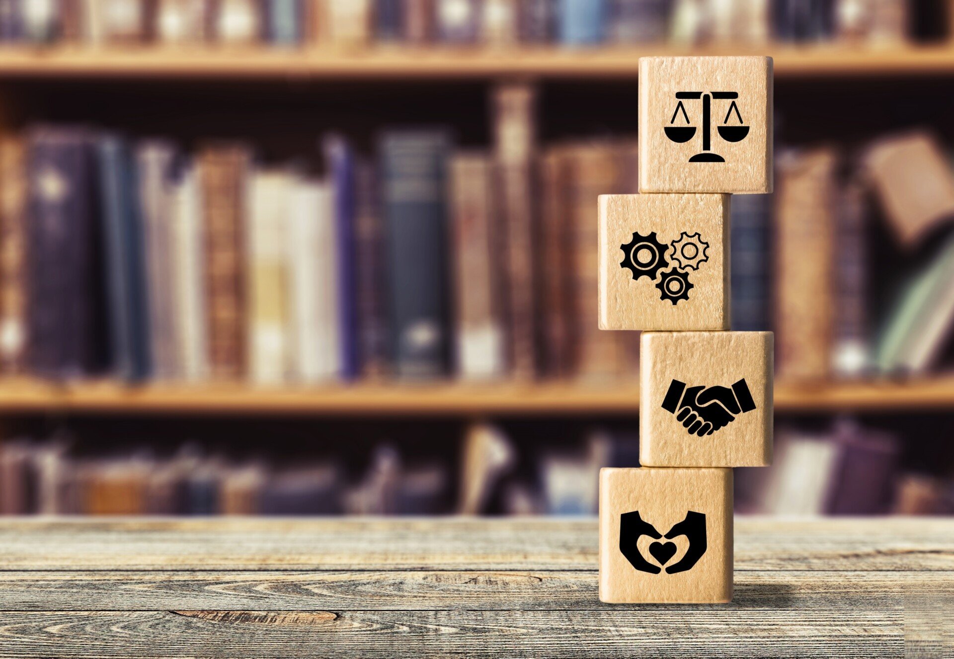 Wooden blocks stacked on a table with icons illustrating different values on them